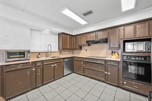 kitchen with under cabinet range hood, black appliances, light countertops, and a sink