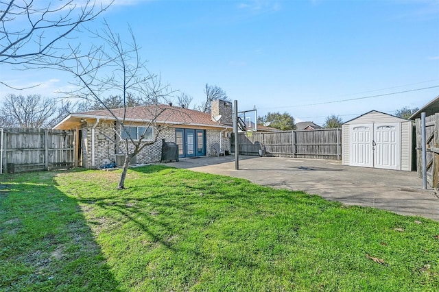 view of yard with a patio, a storage shed, an outbuilding, and a fenced backyard