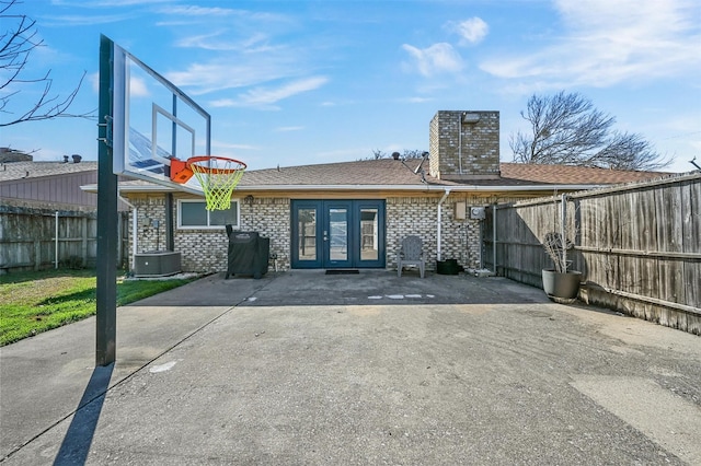 back of property with a patio area, french doors, brick siding, and a fenced backyard