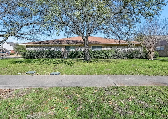 view of front facade featuring brick siding and a front yard