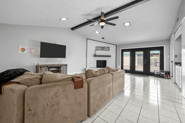 living room with light tile patterned floors, vaulted ceiling with beams, french doors, a textured ceiling, and a brick fireplace