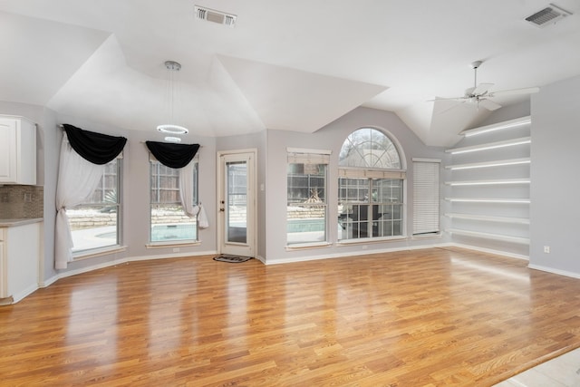 unfurnished living room featuring light wood-style floors, a ceiling fan, visible vents, and lofted ceiling