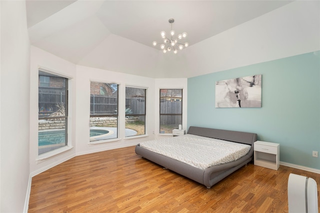 bedroom featuring an inviting chandelier, wood finished floors, and baseboards