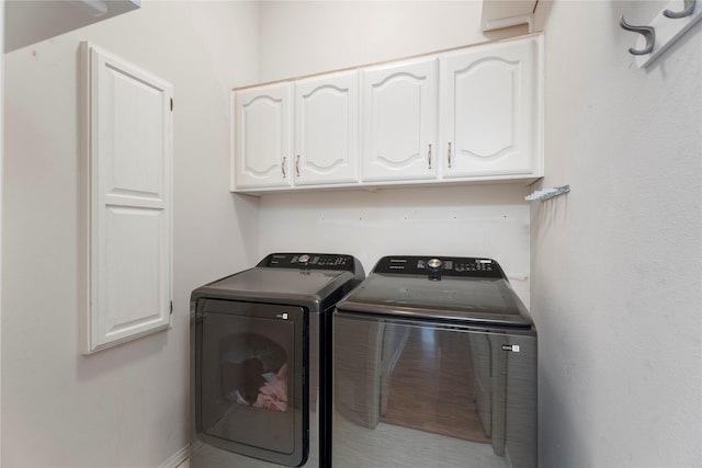 washroom featuring separate washer and dryer and cabinet space