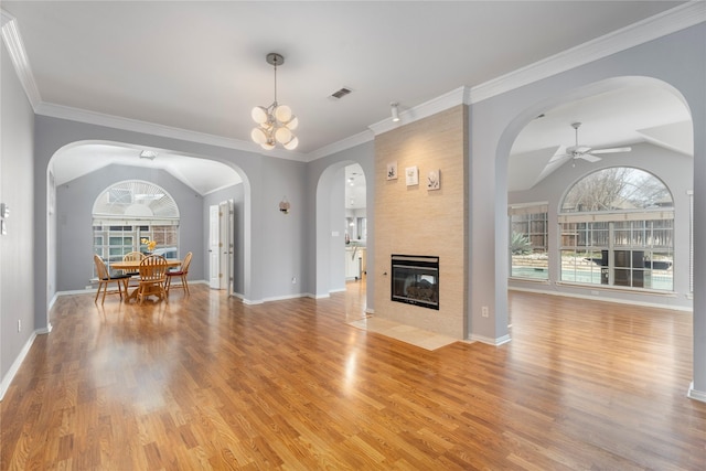 unfurnished living room with lofted ceiling, a ceiling fan, visible vents, and light wood finished floors