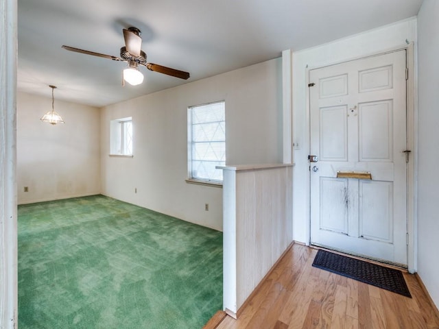 spare room with light colored carpet, light wood-type flooring, and ceiling fan