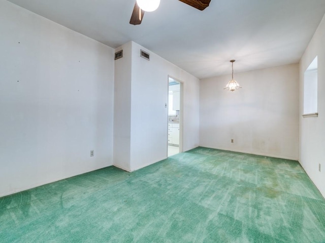 carpeted empty room with visible vents and ceiling fan