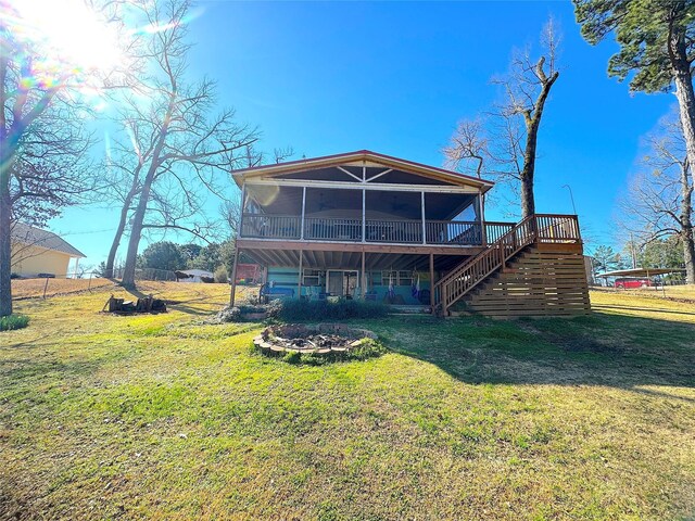 back of house featuring a lawn, a wooden deck, and stairs