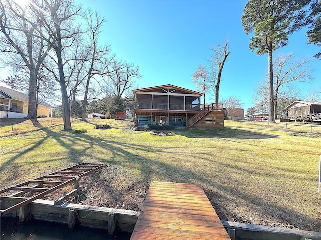 dock area with stairway, a lawn, and a wooden deck