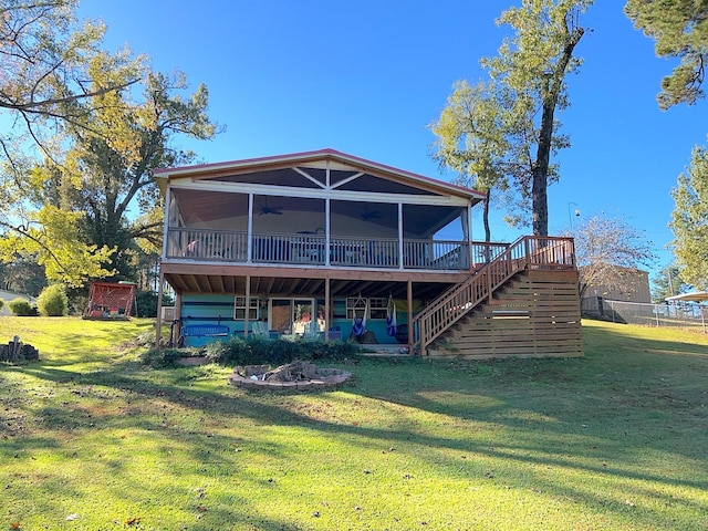 rear view of house with ceiling fan, a yard, a wooden deck, and stairs