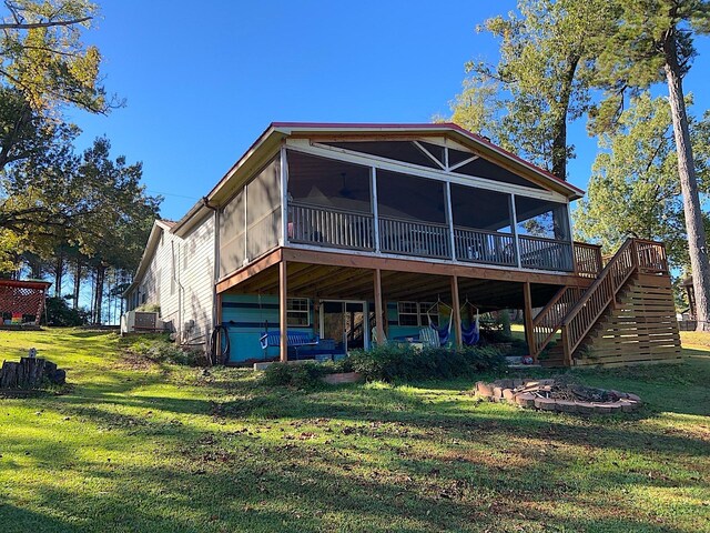 back of property with stairway, a lawn, a sunroom, and a wooden deck