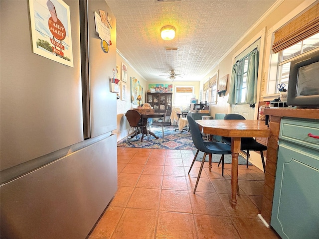 dining room with ceiling fan, light tile patterned floors, an ornate ceiling, and ornamental molding