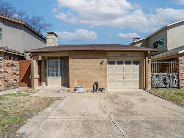 view of front of home with concrete driveway, a garage, brick siding, and a chimney