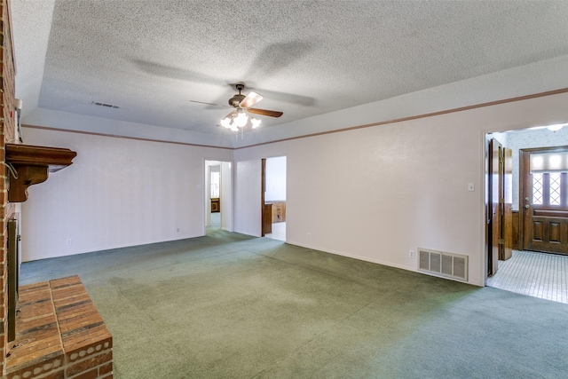 unfurnished living room featuring carpet flooring, visible vents, and a textured ceiling