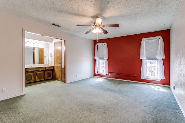 unfurnished bedroom with a ceiling fan, baseboards, visible vents, a textured ceiling, and carpet flooring