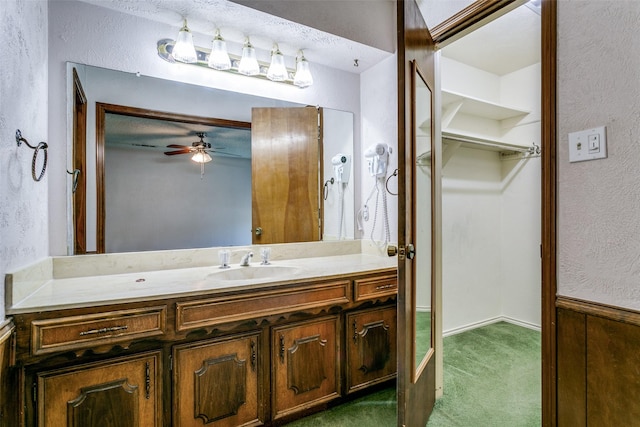 bathroom with vanity, a textured wall, and ceiling fan