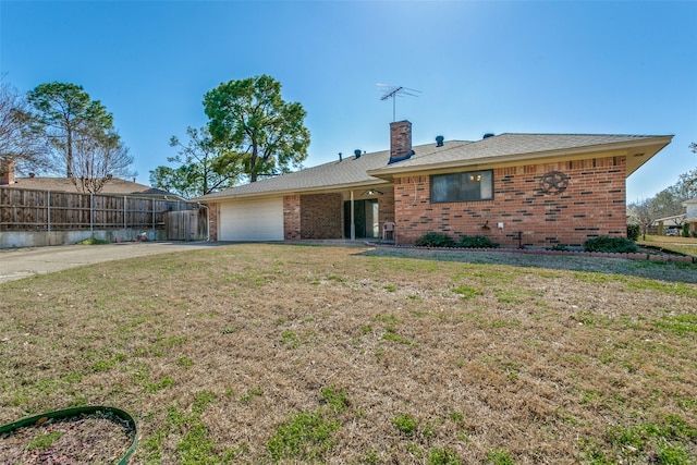 view of front of home with brick siding, fence, a front yard, a chimney, and an attached garage