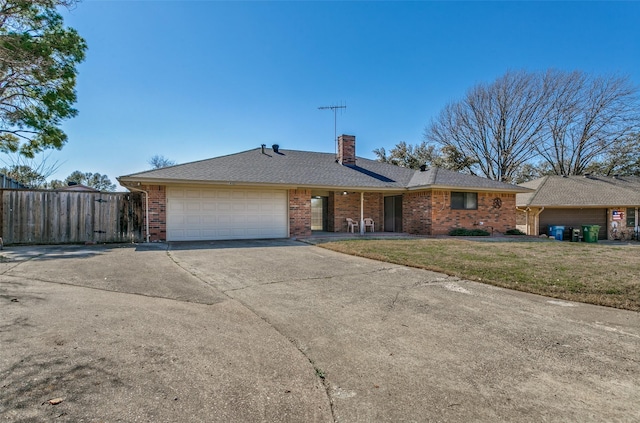 ranch-style house featuring fence, a chimney, a front lawn, concrete driveway, and brick siding