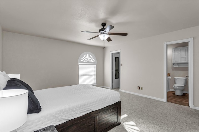 carpeted bedroom with connected bathroom, baseboards, and ceiling fan