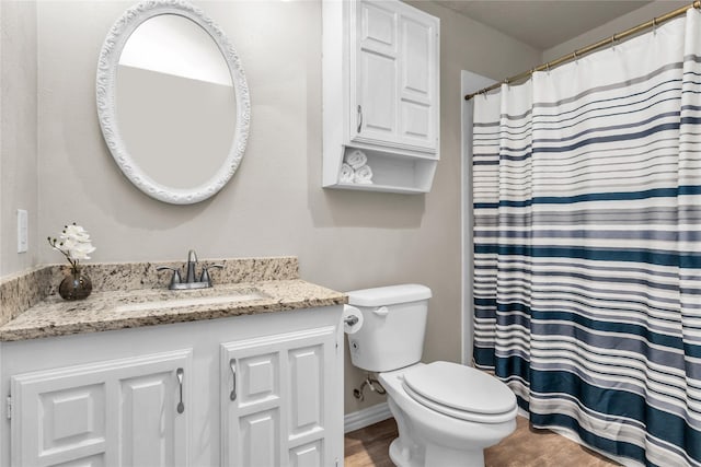 full bath with vanity, wood finished floors, baseboards, curtained shower, and toilet