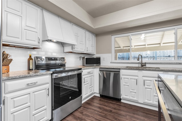 kitchen featuring dark wood-style flooring, a sink, stainless steel appliances, custom range hood, and white cabinets