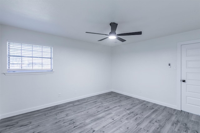 unfurnished room with wood finished floors, baseboards, and ceiling fan