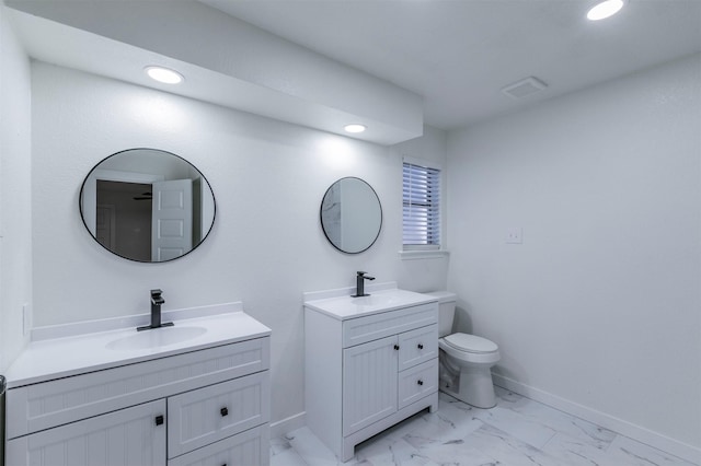 bathroom featuring a sink, baseboards, two vanities, and marble finish floor