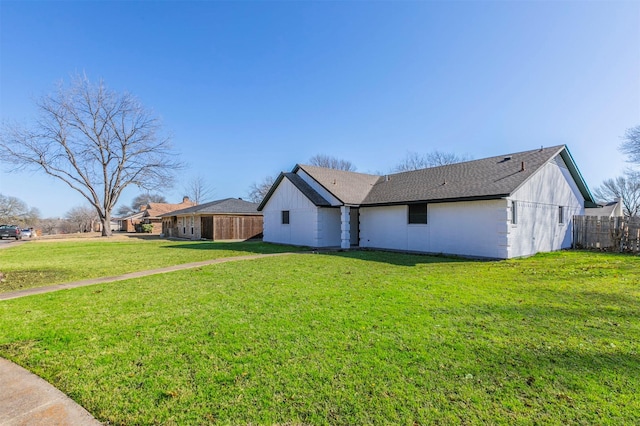 view of property exterior featuring a lawn and fence