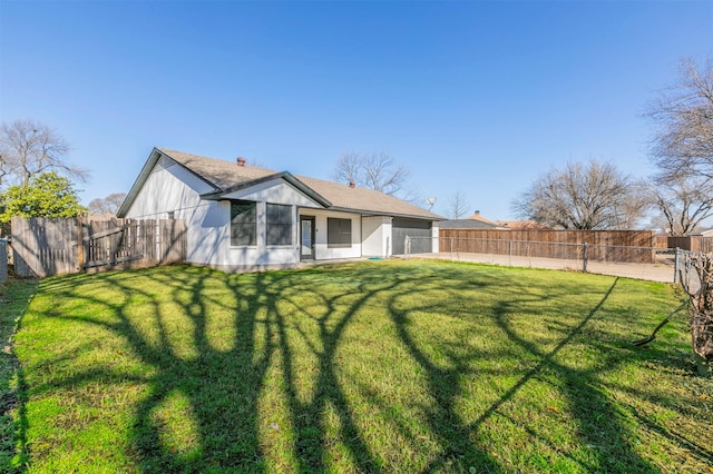 back of house with a fenced backyard and a lawn