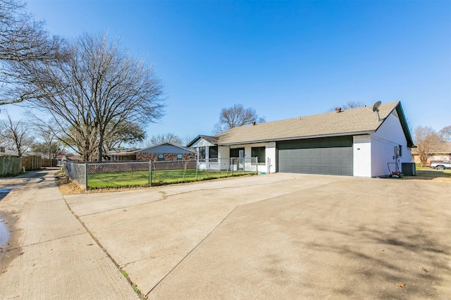 single story home featuring central air condition unit, an attached garage, concrete driveway, and fence