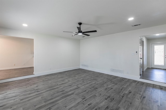 unfurnished room featuring visible vents, baseboards, and dark wood-type flooring