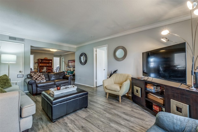 living area featuring crown molding, wood finished floors, and visible vents