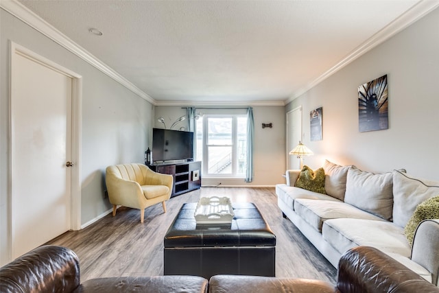 living area with ornamental molding, a textured ceiling, and wood finished floors