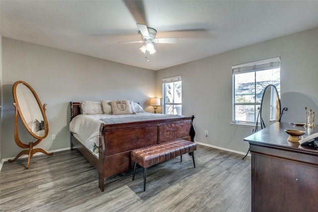 bedroom with baseboards, a ceiling fan, and light wood finished floors