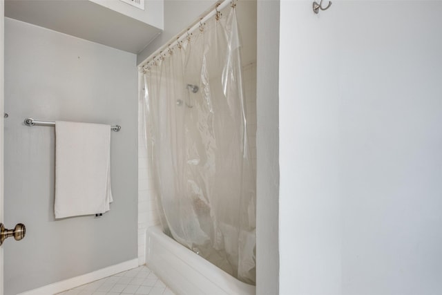 bathroom featuring tile patterned floors, shower / bath combo with shower curtain, and baseboards