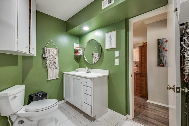 bathroom featuring visible vents, toilet, tile patterned flooring, baseboards, and vanity