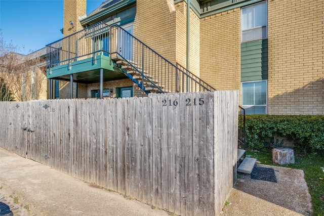 view of home's exterior with a fenced front yard, stairs, and brick siding