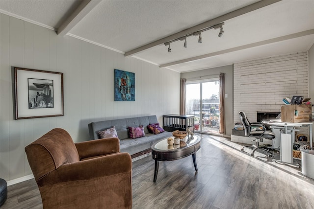 living area with beamed ceiling, a textured ceiling, wood finished floors, and rail lighting