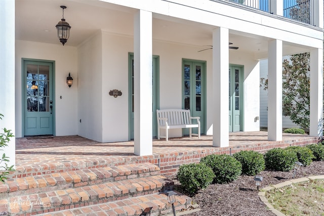 view of exterior entry featuring stucco siding and covered porch