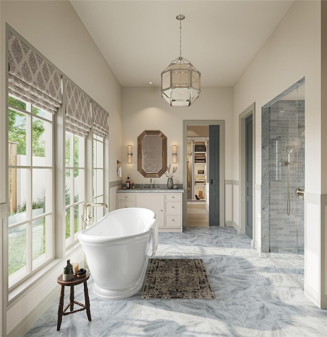 full bath featuring vanity, a shower stall, a spacious closet, and a healthy amount of sunlight