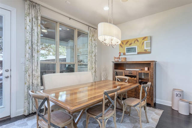 dining space featuring an inviting chandelier, wood finished floors, and baseboards