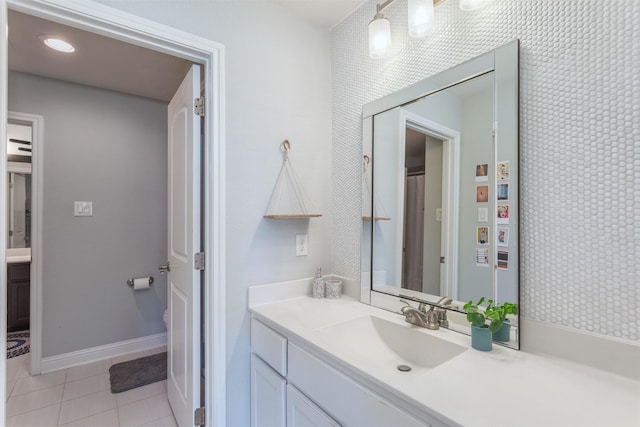 bathroom with tile patterned floors, vanity, and baseboards