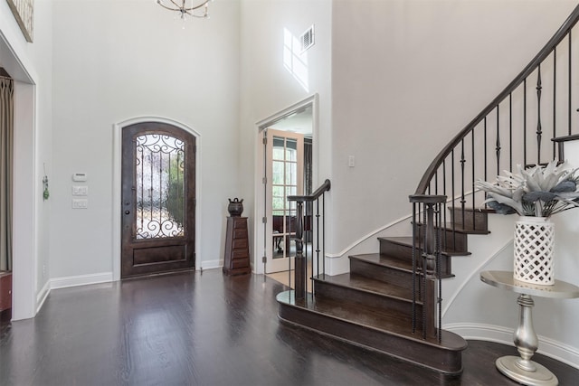 entrance foyer with a high ceiling, wood finished floors, visible vents, and baseboards