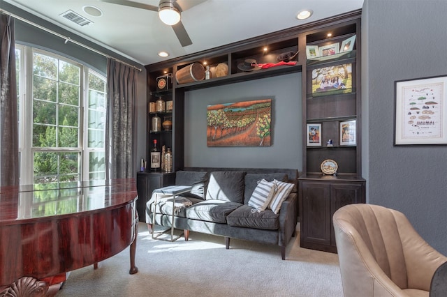 sitting room with visible vents, a ceiling fan, and carpet flooring