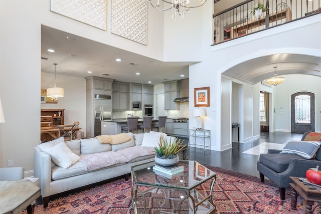 living area featuring arched walkways, baseboards, and an inviting chandelier