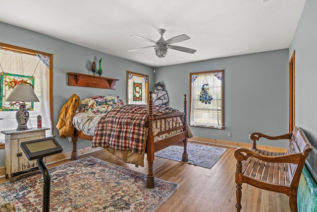 bedroom featuring a ceiling fan, wood finished floors, and baseboards