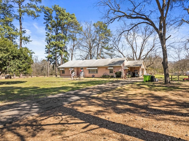 view of front of house featuring driveway and a front yard