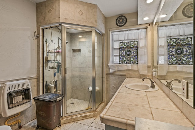 full bath with vanity, heating unit, a stall shower, and tile patterned flooring