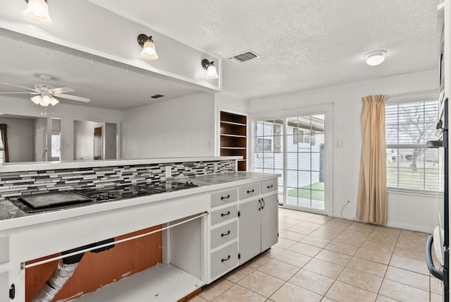 kitchen featuring visible vents, a textured ceiling, light tile patterned floors, decorative backsplash, and black electric stovetop