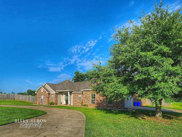 view of front of home with fence, driveway, a front lawn, a garage, and brick siding